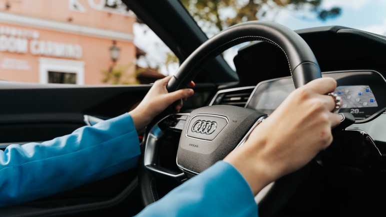 CLOSE UP OF WOMAN HOLDING THE WHEEL IN A NEW AUDI CAR