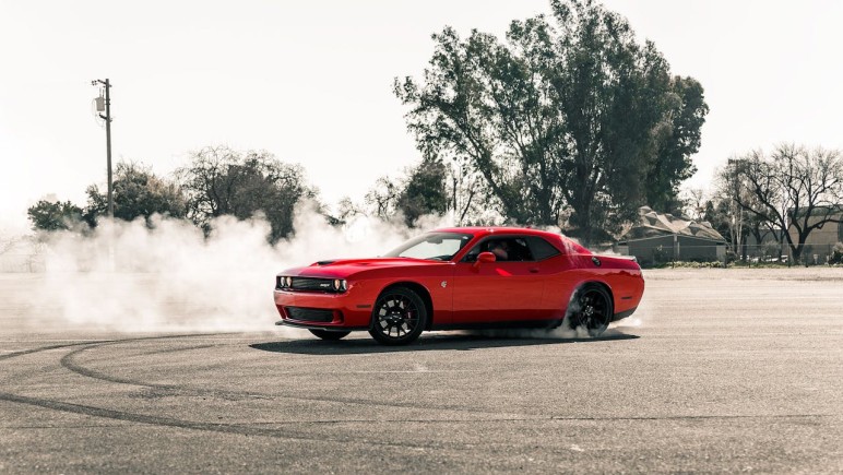 RED COUPE DRIFTING ON ASPHALT ROAD