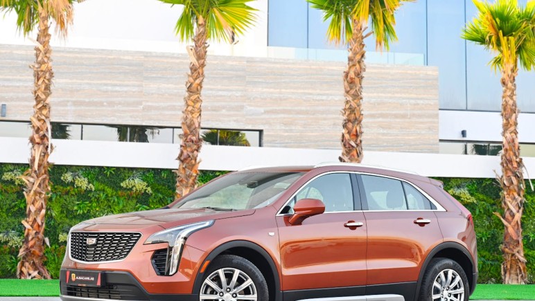 BROWN CAR PARKED NEAR PALM TREES CADILLAC