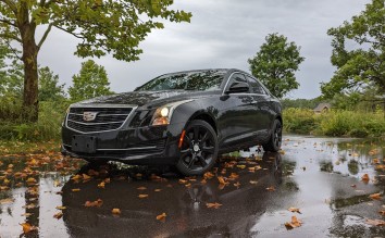 A BLACK CADILLAC CAR PARKED ON THE STREET