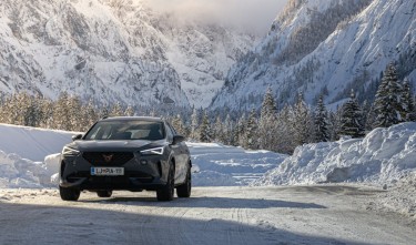 GRAY CUPRA FORMENTOE CAR ON SNOW COVERED ROAD