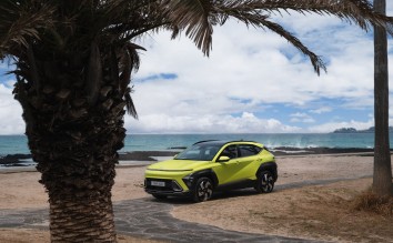 MODERN HYUNDAI KONA PARKED ON A BEACH NEAR PALM TREES