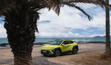 MODERN HYUNDAI KONA PARKED ON A BEACH NEAR PALM TREES