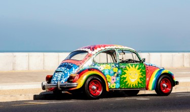 MULTICOLORED VOLKSWAGEN BEETLE ON ROAD