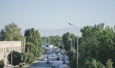 AERIAL VIEW OF A BUSY STREET BETWEEN GREEN TREES