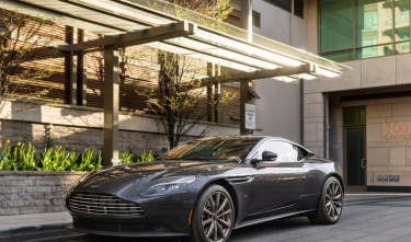 BLACK ASTON MARTIN PARKED NEAR BUILDING