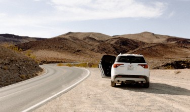 WHITE VEHICLE PARKED BESIDE ROAD,GMC