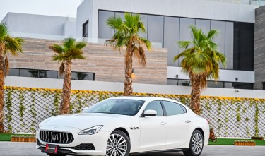 WHITE MASERATI CAR PARKED NEAR PALM TREES