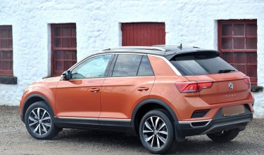 ORANGE SUV PARKED BESIDE WHITE CONCRETE BUILDING VOLKSWAGEN