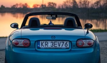 BACK OF BLUE MAZDA MX 5 AT SUNSET