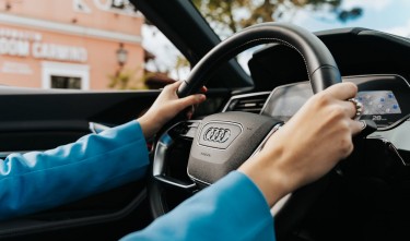 CLOSE UP OF  WOMAN HOLDING THE WHEEL IN A NEW AUDI CAR