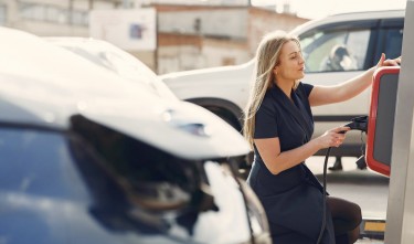 MODERN WOMAN USING STATION FOR CHARGING ELECTROMOBILE