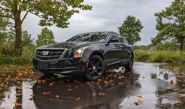 A BLACK CADILLAC CAR PARKED ON THE STREET