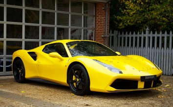 YELLOW FERRARI 458 ITALIA PARKED NEAR WHITE WOODEN FENCE