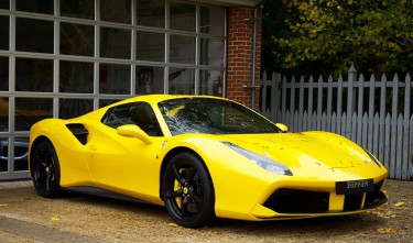 YELLOW FERRARI 458 ITALIA PARKED NEAR WHITE WOODEN FENCE