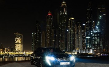 CAR PARKED ON RIVERSIDE NEAR CITY BUILDINGS