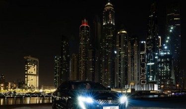 CAR PARKED ON RIVERSIDE NEAR CITY BUILDINGS