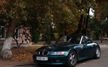 CONVERTIBLE BMW CAR PARKED ON THE STREET NEAR TREES