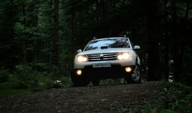 PHOTO OF A VEHICLE ON DIRT ROAD SORROUNDED BY TALL TREES RENAULT