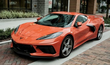 A PARKED ORANGE CHEVROLET CORVETTE