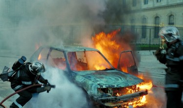 FIRE FIGHTHERS EXTINGUISHING A BURNING CAR 