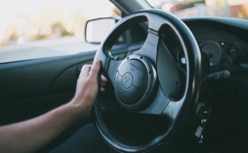 PERSON HOLDING A BLACK MITSUBISHI MOTORS STEERING WHEEL