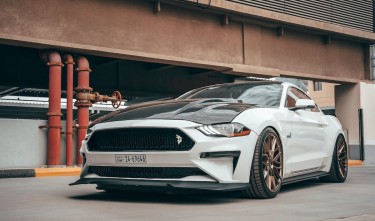 WHITE FORD MUSTANG PARKED ON SIDEWALK