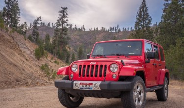 RED JEEP IN THE MIDDLE OF A DIRT ROAD