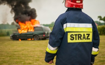 FIREMAN WATCHING FLAMING VEHICLE 