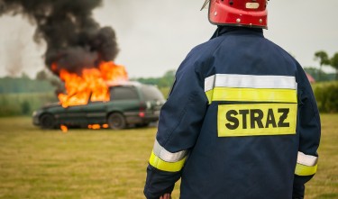 FIREMAN WATCHING FLAMING VEHICLE 