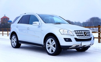 WHITE MERCEDES-BENZ SUV PARKED BESIDE BROWN WOODEN FENCE