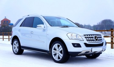 WHITE MERCEDES-BENZ SUV PARKED BESIDE BROWN WOODEN FENCE