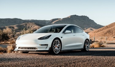 WHITE TESLA CAR ON THE ROAD 