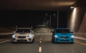 BLUE AND WHITE SPORTS CAR RIDING ON EMPTY ROAD AT NIGHT