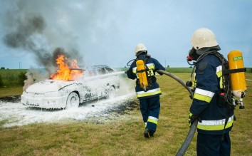 FIREMEN SPRAYING ON FLAMING VEHICLE