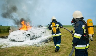 FIREMEN SPRAYING ON FLAMING VEHICLE