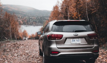 BACK VIEW OF AN SUV CAR PARKED ON A DIRT ROAD