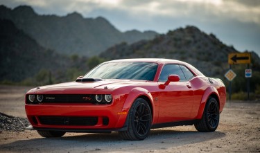 RED DODGE CHALLENGER PARKED ON UNPAVED ROAD 