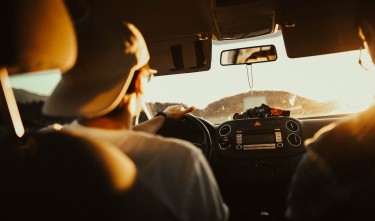 A MAN HOLDING THE STEERING WHEEL WHILE DRIVING