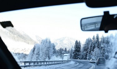 ROAD BETWEEN SNOW COVERED TREES