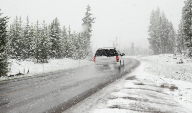 WHITE SUV ON ROAD NEAR SNOW COVERED TREES